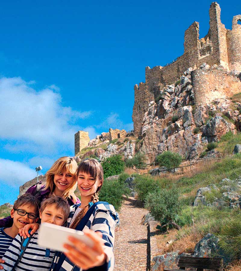 Una familia se toma una selfie frente a un castillo.