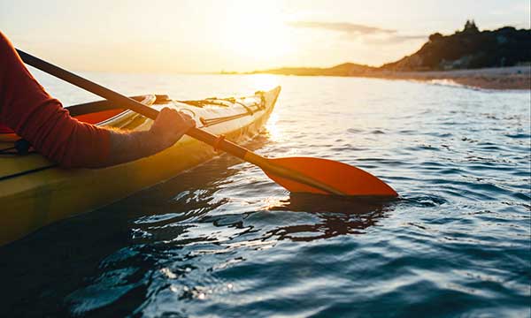 Una persona remando en kayak en un embalse.